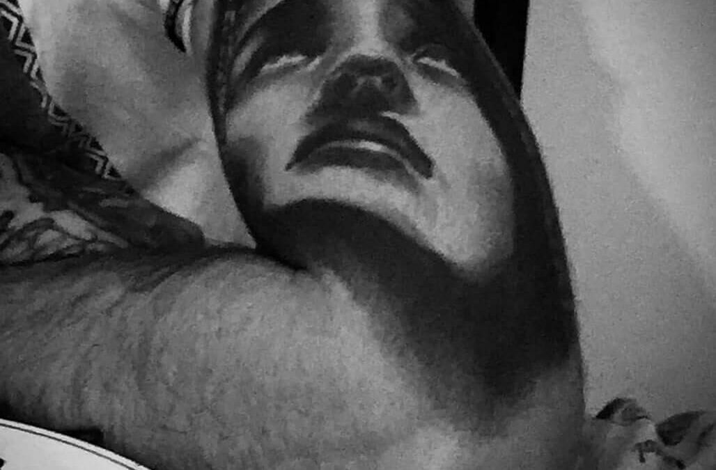 Foto de un tatuaje de de una cara sobre el brazo con estilo realista hecho por un tatuador de kaifa´s tattoo studio en Madrid