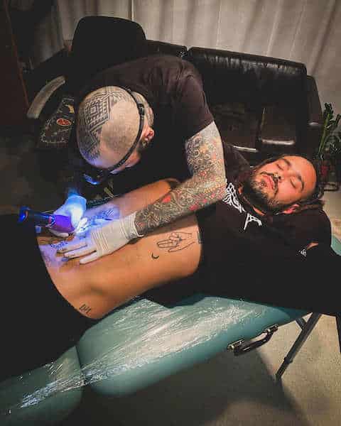 Oscar Marko tatuando a un chico en el pecho