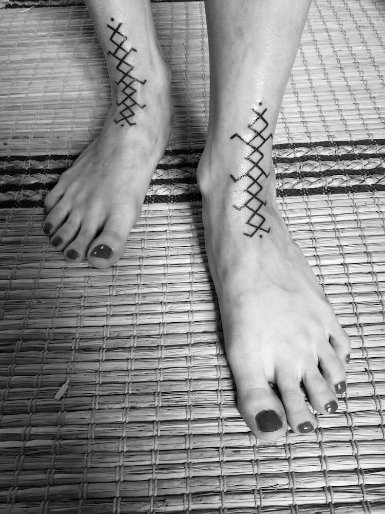 Foto en blanco y negro de los pies de una mujer con tatuajes estilo Hand Poked realizados en Kaifa´s Tattoo Studio Madrid (Moncloa Chamberí)