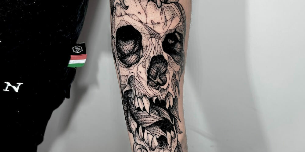 Foto de un brazo tatuado con una calavera con estilo de tatuaje blackwork por Carlos cuervo, tatuador de kaifa´s tattoo studio en Madrid