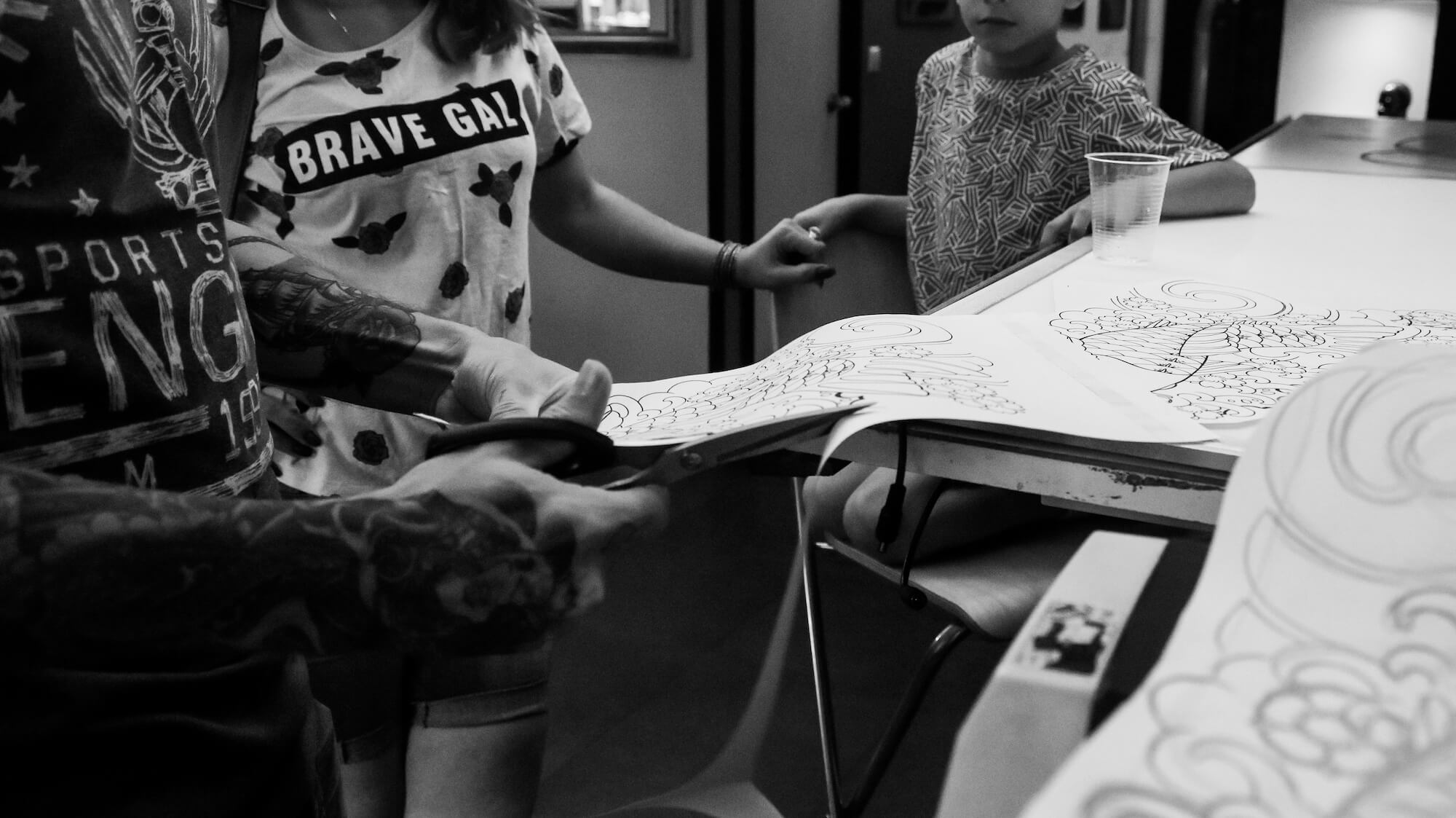 foto en blanco y negro en el Estudio de tatuajes y piercings Kaifa´s Tattoo Madrid en la zona de Chamberí. Se ve cómo diseñan