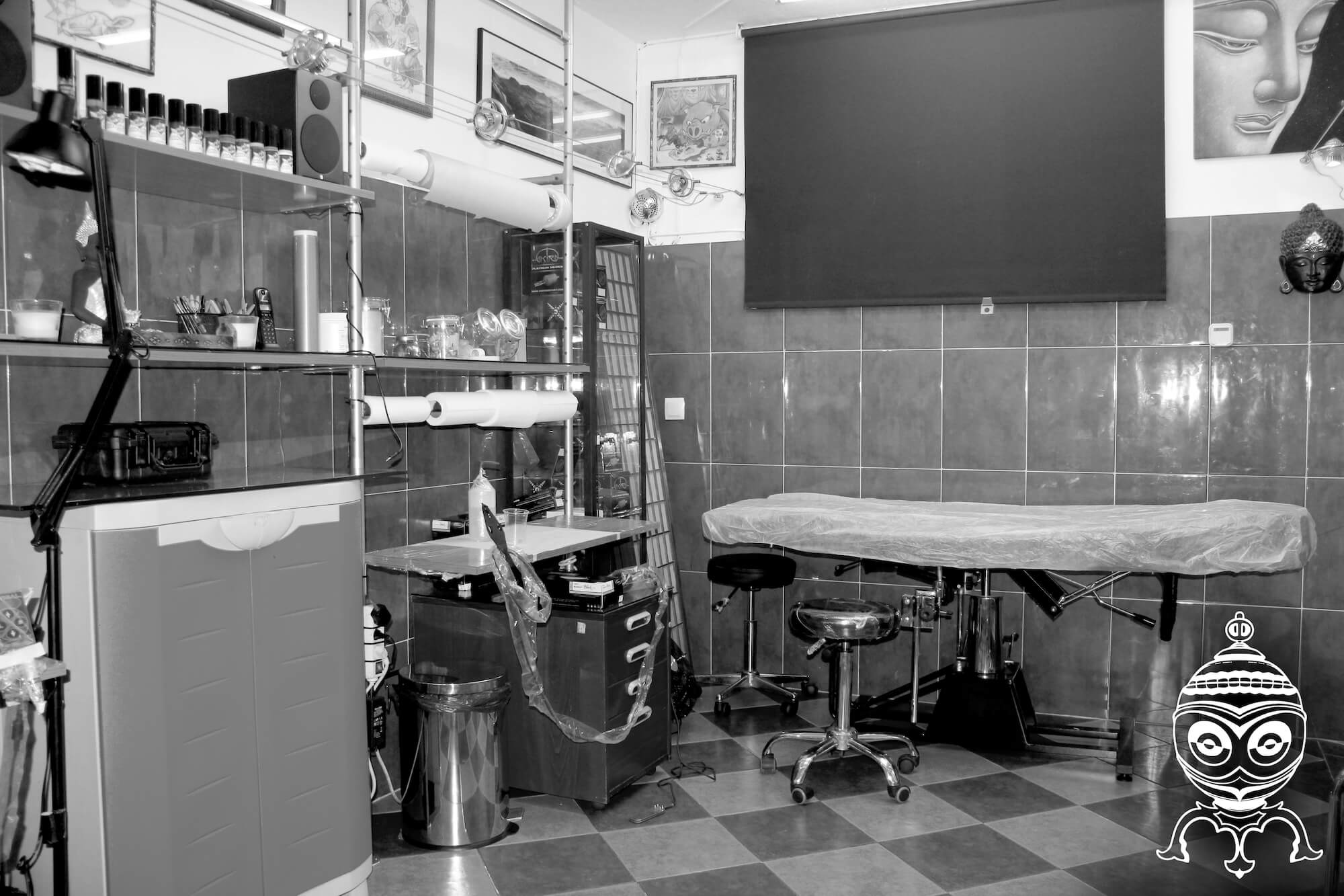 foto en blanco y negro en el Estudio de tatuajes y piercings Kaifa´s Tattoo Madrid en la zona de Chamberí. Se ve una de las salas de tatuaje con camilla y material vegano