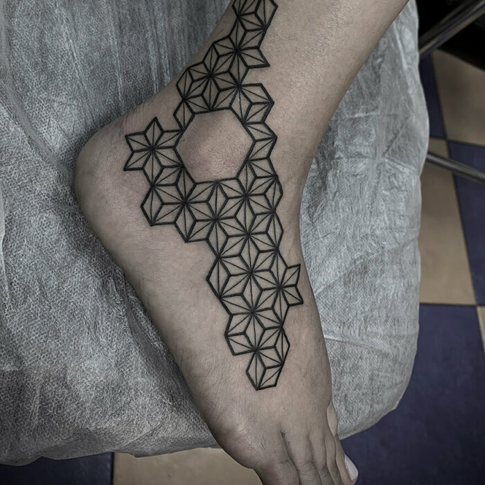 Foto de un tatuaje realizado por el tatuador Gennaro sacco en kaifa´s tattoo Studio Madrid, con estilo geometric, con materiales cruelty free, tattoo en lateral de pie y tobillo